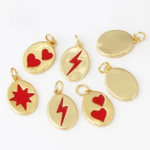 Flat lay of red enamel and gold-plated heart, lightning, and star DIY charms on white background