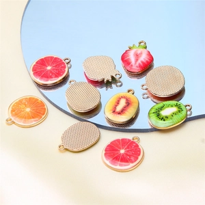 Macro detail of mixed fruit alloy pendants with golden textured backing for DIY jewelry