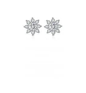 Macro shot of silver snowflake earrings with moissanite studs and symmetrical petals