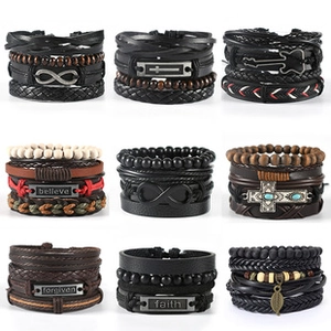 Macro detail of multilayer leather bracelets with wood beads and engraved metal plates