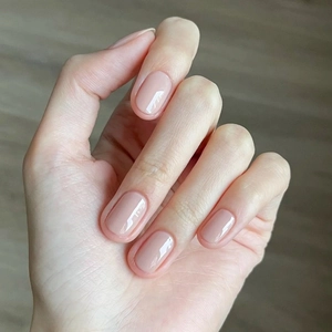 Elegant glossy nude pink press-on nails in a French short style for a natural manicure