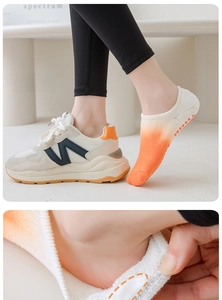 Close-up of orange gradient pilates socks with non-slip silicone grip on the heel