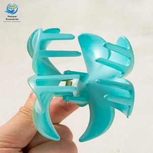 Detail of cyan blue large hair claw clip with golden metal spring and gradient design