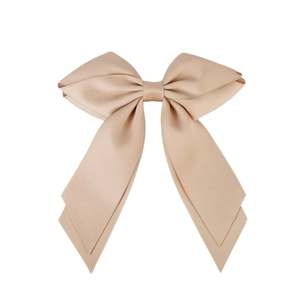 Barrette à cheveux nœud en soie beige avec de longs rubans sur fond blanc pur