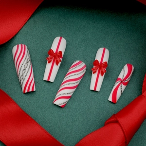 Extra long Christmas press-on nails with red bows and candy cane glitter stripes