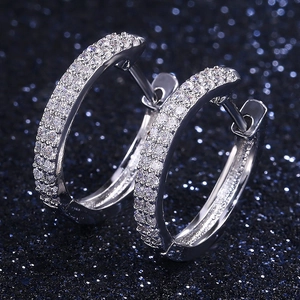 Elegant silver geometric hoop earrings with sparkling cubic zirconia on starry background