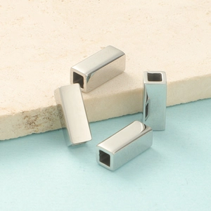 Macro view of four hollow rectangle titanium steel beads for DIY jewelry making