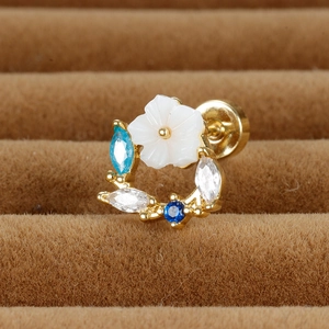Vue macro de la boucle d'oreille fleur avec zircons bleus et fermoir doré