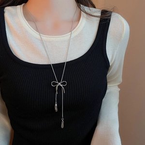 Silver bowknot pendant long necklace with tassels worn by model for fashion display