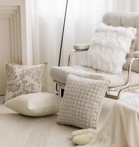 Mix of beige plush and textured branch pattern decorative pillows on a cozy armchair