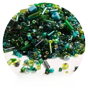 Macro view of Miyuki forest green glass seed beads in various geometric shapes
