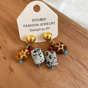 Close-up of vintage floral stone earrings with S925 silver pins on a wooden surface