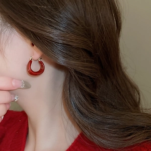 Vue détaillée des boucles d'oreilles en U plaquées or 14K avec émail rouge sur modèle
