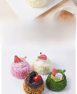 Detail of faux coconut cake models with strawberry, cherry and cream decorations