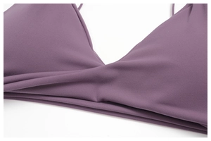 Close-up of V-neck sports bra featuring crossover pleat details and triangle cups