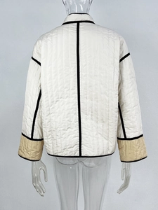 Detailed back view of a quilted cropped jacket with contrast black piping and beige accents