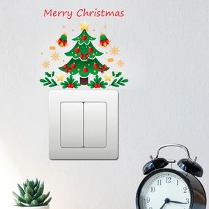 Christmas tree wall stickers and red berry decals decorating a white light switch panel