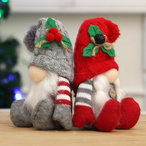 Christmas plush gnomes set with knitted hats and festive berry decorations on wood