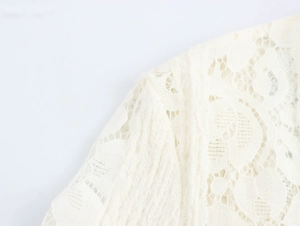 Close-up of intricate white lace pattern and mesh texture on a French style maxi dress
