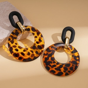 Detailed close-up of acrylic leopard print hoop earrings with vintage geometric accents