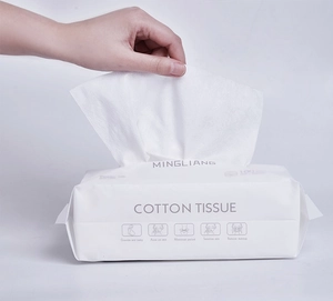 Close-up of hand pulling white extra-thick cotton face tissue from a portable soft pack