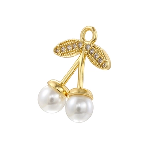 Macro shot of gold-plated cherry charm with white pearls and sparkling cubic zirconia