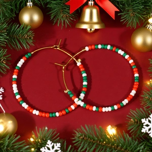 Detail of bohemian red green and white beaded hoop earrings on Christmas background