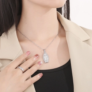 Dettaglio della collana con medaglia della Vergine Maria e anello trapuntato su modella