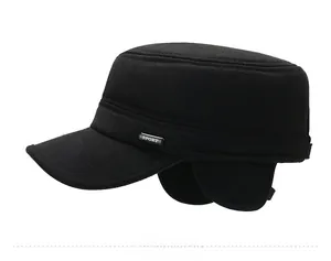 Detail of men's black flat top winter hat with ear flaps and metal sport emblem