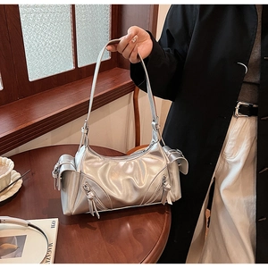 Silver metallic shoulder bag detail showing glossy leather texture in cafe setting