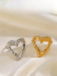 Macro shot of gold and silver heart rings featuring unique irregular hammered metal textures