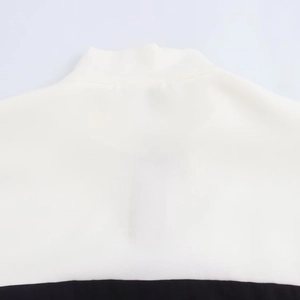 Detailed close-up of the high-quality stitching on the white and black stand-up collar