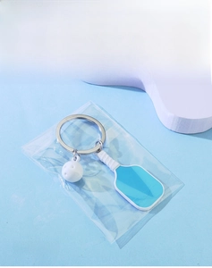Detailed view of blue pickleball paddle keychain with white ball and silver metal ring
