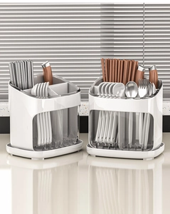 Detail view of transparent kitchen utensil holder with drainage tray and multiple compartments