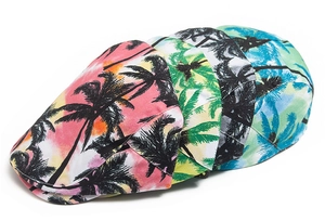 Dettaglio di quattro berretti piatti in cotone con stampe tropicali di palme e colori tie-dye