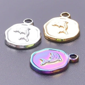 Macro shot of 18k gold plated dolphin relief pendants in gold silver and rainbow finishes