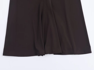 Detailed view of the dark brown dress hem showcasing premium fabric texture and drape