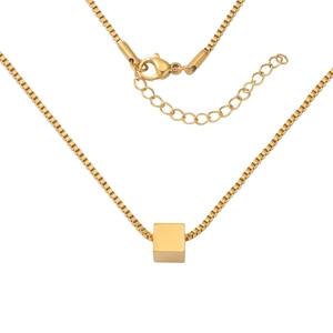 Detail shot of a golden box chain necklace with a cube pendant and secure lobster clasp