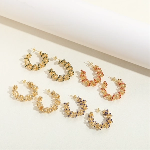 Detail of 14K gold-plated C-shaped hoop earrings set with colorful multi-colored crystals