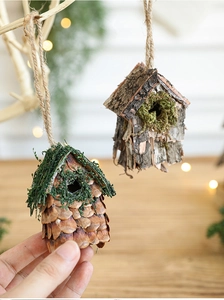 Détail d'un nichoir décoratif fait main avec écorce naturelle, pommes de pin et mousse