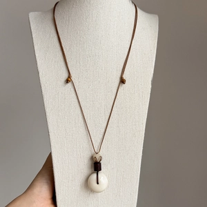 Détail du pendentif Bodhi avec perles en bois sur un collier ethnique ajustable zen