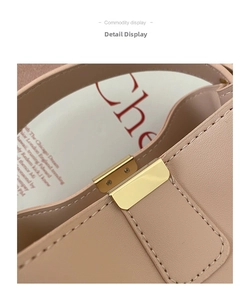 Detail of light pink leather bag showing golden metal clasp and fine stitching
