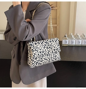 Detail of leopard print tote bag with gold chain strap and stylish flap closure