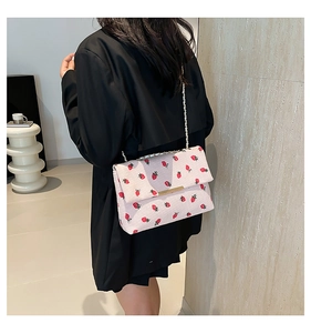 Back view of a woman wearing a stylish strawberry pattern rectangular shoulder bag