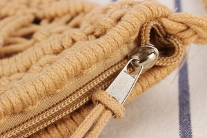Close-up of hand-woven cotton rope texture and premium silver metal zipper on beach bag