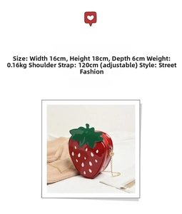 Detail view of red strawberry cross-body bag with gold zipper and chain strap