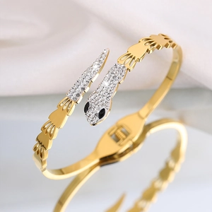 Golden snake-shaped titanium steel bracelet with sparkling rhinestone pavé and black eyes
