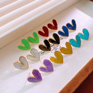 Macro shot of colorful enamel heart earrings with gold trim in a luxury display box