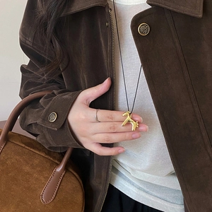 Cute gold pony pendant necklace with black cord for women shown on a fashion model