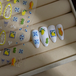 Detail of bohemian lemon and floral nail stickers on a textured beige velvet surface